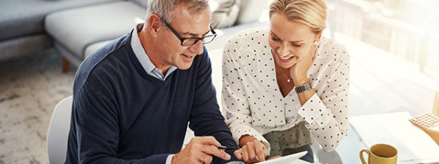 Mature couple researching on laptop