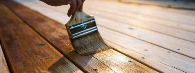 Investor applying varnish to deck